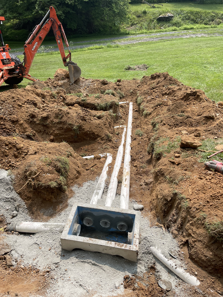 Installation of new septic system distribution box and drain field lines.