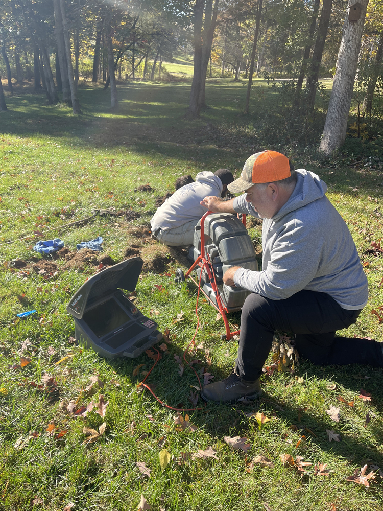 Technicians conducting a septic system inspection using camera equipment