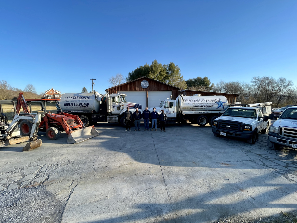 Septic service team with trucks and equipment at their facility.