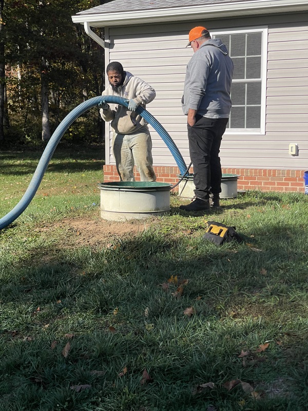 Technicians performing routine septic tank pumping and maintenance service.