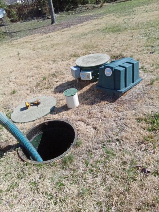 Commercial septic pumping in progress with open tank and equipment setup.