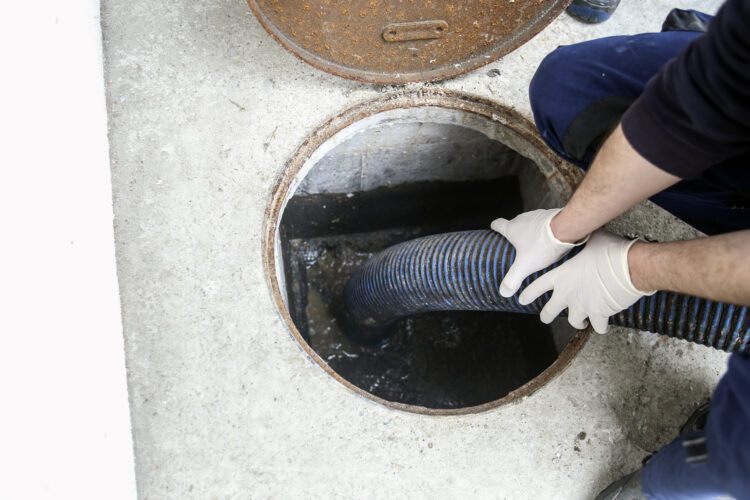 Technician performing routine septic pumping service