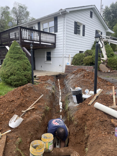 Installing a new septic system with piping laid in a trench for connection