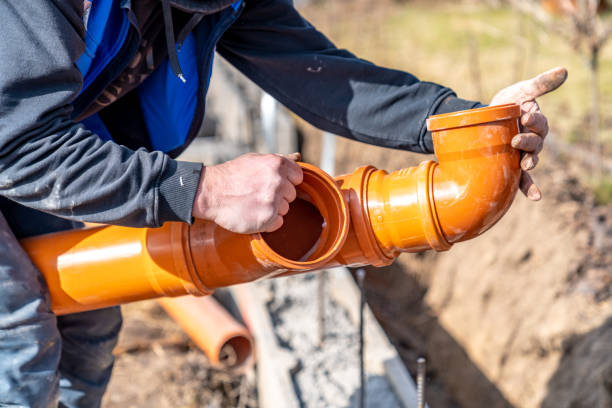 Worker assembling sewer line with durable PVC fittings