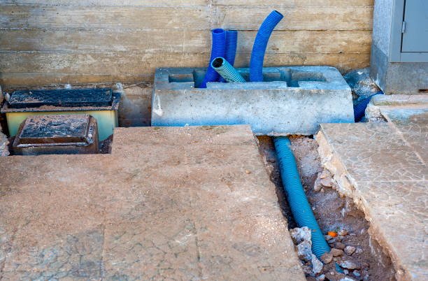 Damaged concrete baffle with exposed blue drainage pipes needing repair services