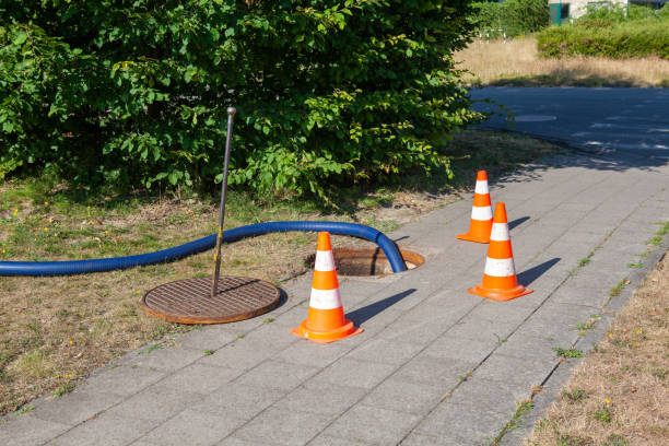 Septic pumping hose connected to a tank at a school site