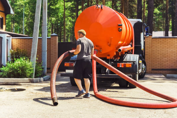 A technician handling the hose for quarterly septic pumping services