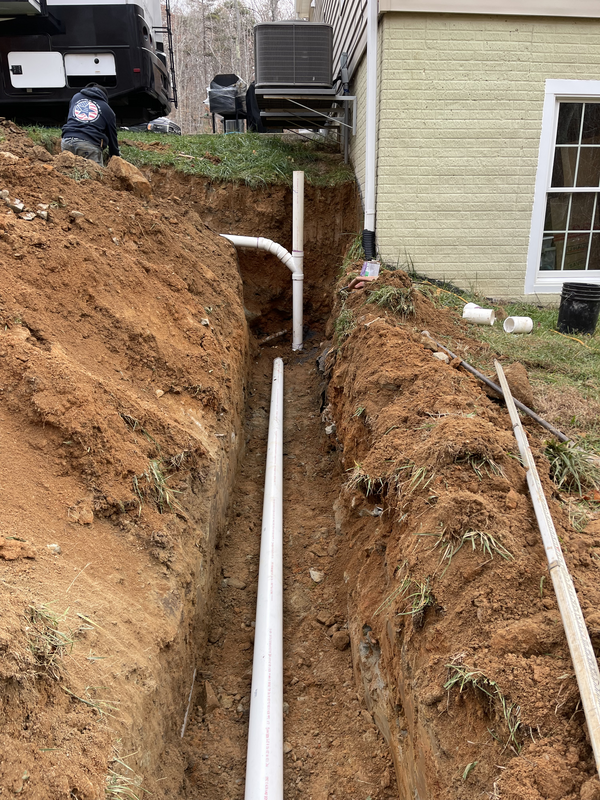 Workers repairing septic drain field with updated drainage piping