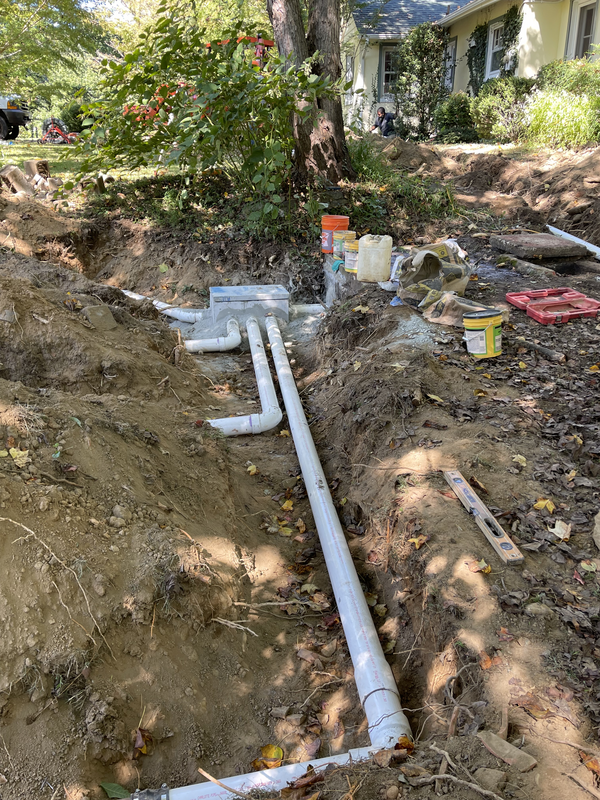 Septic drain field repair underway with exposed piping and tools
